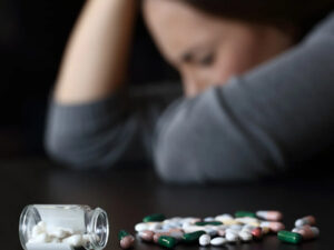 Woman who seems in agony, with the focus on spilled drugs